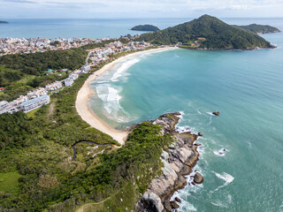 Aerial view of Bombinhas beaches with buildings, sand, rocks and forest