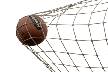 Vintage brown leather football captured mid-action within a white goal net, celebrating a decisive score. background removed