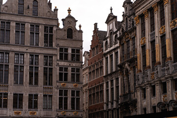 Fototapeta premium Daytime view of the historic Grand Place square surrounded by ornate guildhalls under a cloudy sky