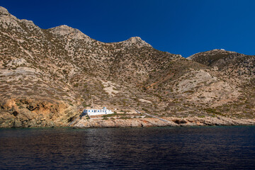 A typical small greek orthodox chapel (Church of St Catherine) sits at the bas of steep mountains...