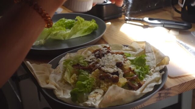 Woman preparing a fresh durum wrap with mayonnaise enjoying a meal inside a camper van