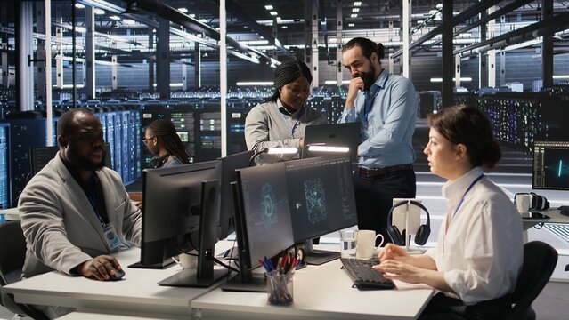Data center engineers performing maintenance on blade server units used for artificial intelligence processing. IT professionals manage data center arrays used for machine learning training, camera A