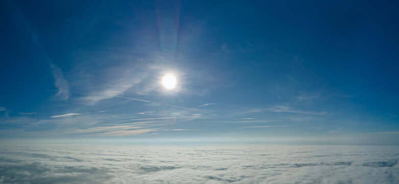 Aerial view from high altitude of earth covered with white puffy cumulus clouds on sunny day