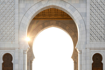 Fototapeta premium Grand marble archway with intricate Islamic patterns and a golden ceiling, featuring a green transparent cutout and warm sunlight. Ornate wooden details. background removed