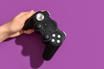 Female hand with modern game pad on purple background, closeup © Pixel-Shot