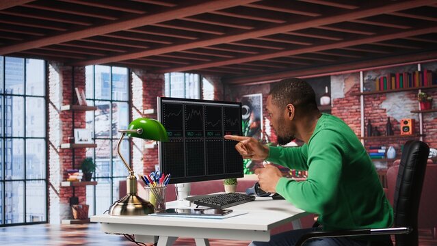 Cheerful day trader gaining money via stock market exchange, maximizing profits by following forex trends and candle stick charts. Thrilled african american broker investor. Camera B.