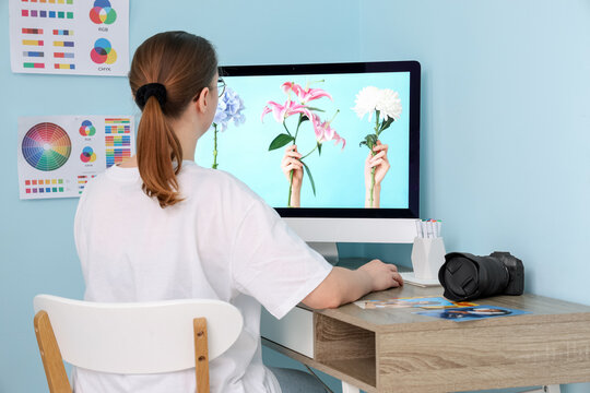 Female photographer working with computer at table in studio, back view