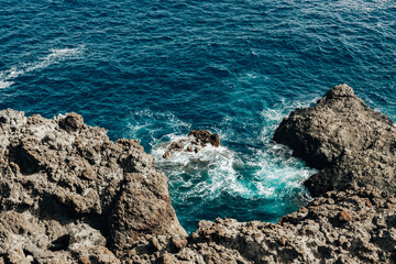 A beautiful view of the rocky shore against which the ocean waves crash.