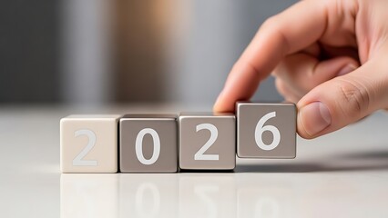 Dynamic Transition to 2026 A Hand Expertly Arranges Numeric Blocks, Symbolizing Swift Progress and Meticulous Planning for Future Opportunities and Growth