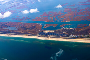 View from above of an airplane flying over the coast of North America.