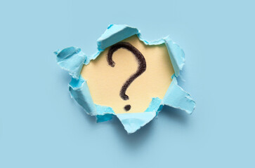 Question mark visible through torn paper on color background