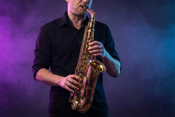 Fototapeta premium A Musician Playing a Golden Saxophone Against a Moody Purple and Blue Background