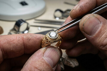 Expert jeweler meticulously setting a brilliant diamond into an ornate gold ring with precision tools