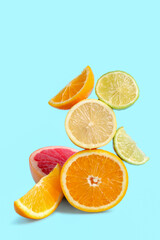Different cut citrus fruits on blue background