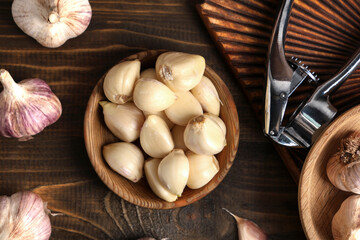 Bowl with fresh garlic cloves on wooden background