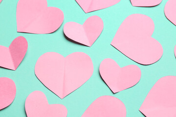 Pink paper hearts on turquoise background. Valentine's Day celebration