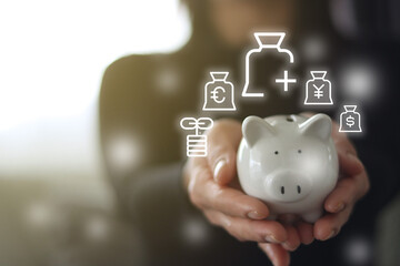 women hand holding white piggy bank with money icon 