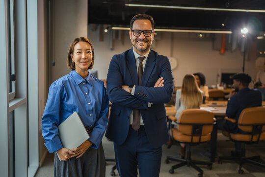 Diverse business team partners standing confidently in modern office