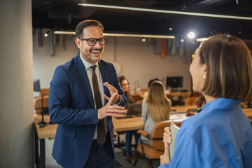 Smiling business colleagues enjoying a casual conversation in the office