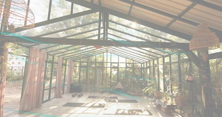 Showing glass sunroom bathing in sunlight at garden-facing conservatory, with wicker lamps © vectorfusionart