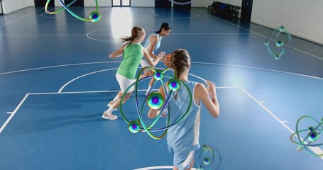 Running female basketball player in light-blue kit moving down blue court, showing 3D atom overlays