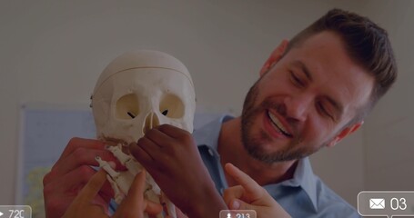 Smiling teacher in blue shirt holding skull, showing features in class, hands and jaw, copy space