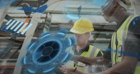 Reviewing handheld tablet two workers in high-vis vests and yellow hardhat at factory, AR graphics