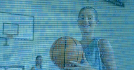 Smiling woman in jersey holding orange basketball facing lens at gym with hoop overlay, copy space
