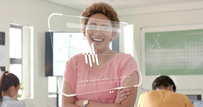 Smiling instructor in pink top, glasses standing front of classroom, showing AR chart and laptops - Powered by Adobe
