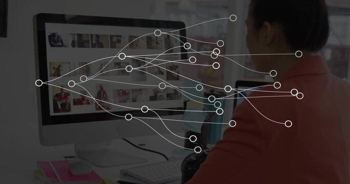 Reviewing woman in coral-blazer scrolling monitor thumbnails at desk with DSLR, nodes, copy space - Powered by Adobe