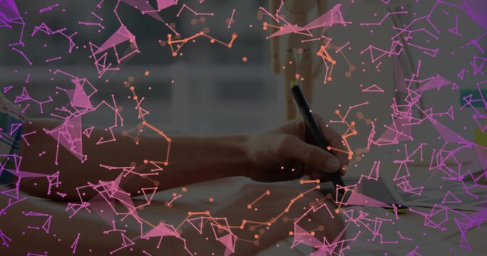 Holding stylus, hand wearing patterned shirt drawing on tablet at desk with purple data overlay