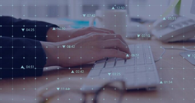 Typing female hands wearing dark sweater pressing keys on white keyboard at desk, showing data grid