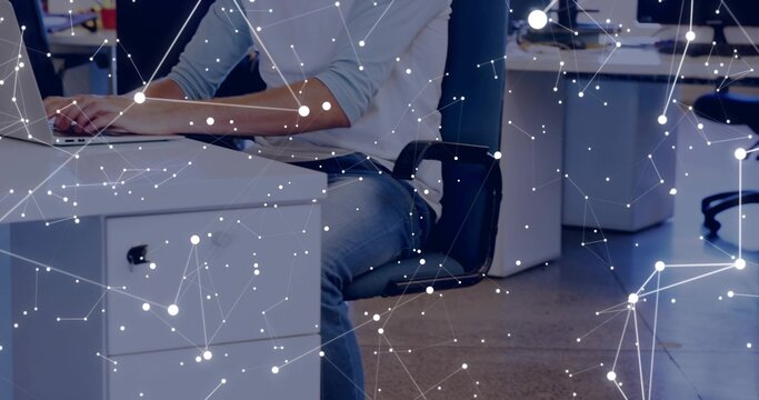 Working adult male typing on laptop at open-plan office in light shirt blue jeans, network overlay - Powered by Adobe