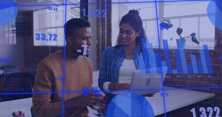Discussing woman in blue plaid, man in brown sweater holding laptop at desk, showing data overlays