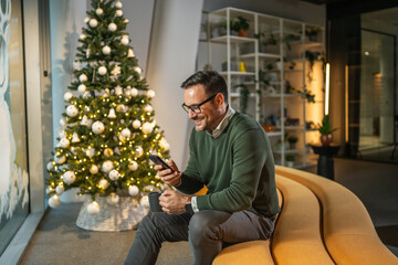 Man smiling using phone during christmas holiday in office
