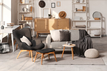 Modern interior of living room with grey sofa and stylish armchair