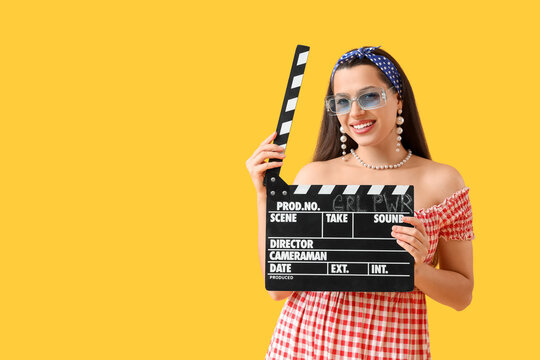 Young pin-up woman holding movie clapper with text GRL PWR on yellow background. Women's History Month
