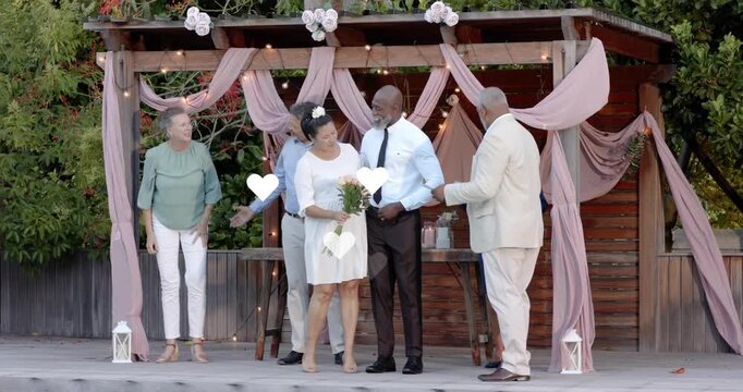 Officiant reading vows, couple stepping forward on wedding pergola deck, animated hearts floating