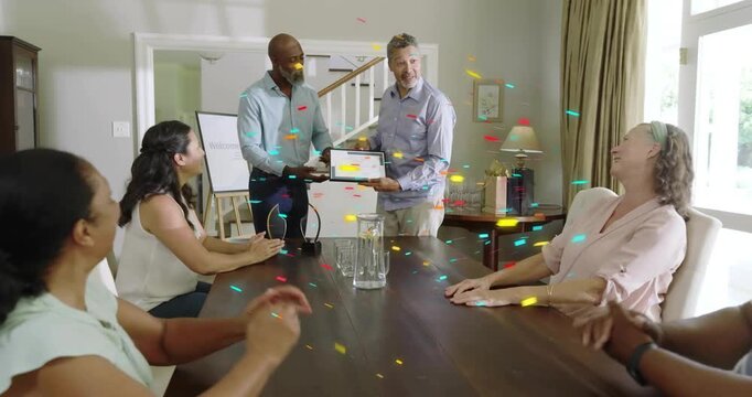 Host handing award as family clapping, recipient rising and accepting award, confetti at table