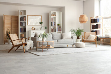 Bookcases, cozy sofa, wicker armchairs and coffee table in interior of stylish living room