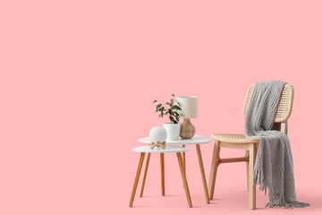 Plaid on wooden chair and coffee table with decor on pink background
