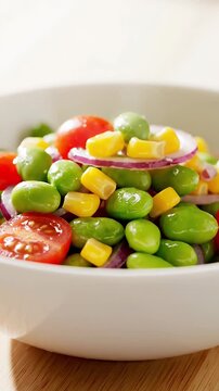 Vibrant and Fresh Edamame Corn Salad with Cherry Tomatoes and Red Onion in a White Bowl a Healthy and Colorful Vegan Meal or Side Dish Close-Up