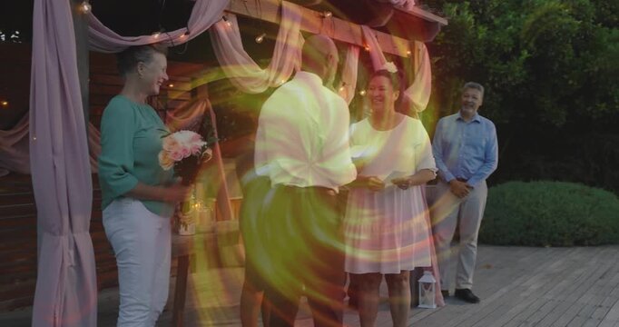 Couple exchanging wedding vows while reading cards on deck, swirl briefly hiding pergola and couple