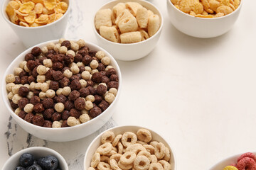 Bowls with different tasty cereals on grunge white background