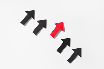 Naklejka premium Red arrow among black ones on white background