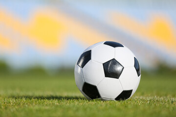 Fototapeta premium Soccer ball on green stadium grass, closeup