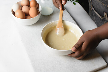 Overhead view of flour being stirred into cake batter, process of mixing cake batter