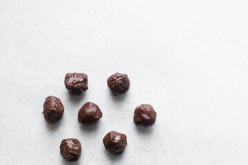Overhead view of chocolate sugar cookie dough on white granite countertop, top view of portioned chocolate cookie dough balls