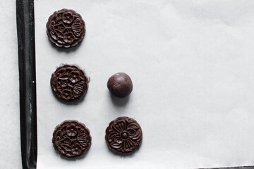 Overhead view of stamped chocolate cookies on a parchment lined tray
