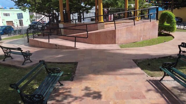 Daytime view of the walkway and benches at Parque de La Ermita in M&eacute;rida, next to the historic church, emphasizing cultural tradition, religious heritage, and colonial ambiance.